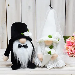 Close-up detail view of handmade bride and groom wedding gnomes on rustic wooden background