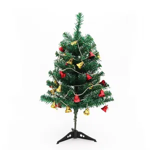 Mini árbol de Navidad artificial decorado con campanas rojas y doradas sobre fondo blanco