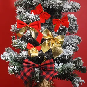 Detailansicht von roten Samt- und goldmetallischen Weihnachtsschleifen am Tannenbaum