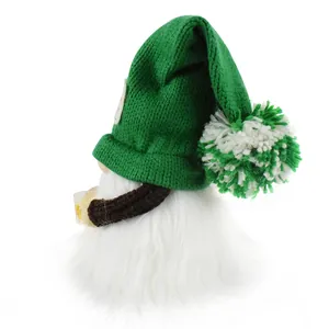 Side view detail of a green knitted beer gnome plush with a fluffy white beard and pom-pom.