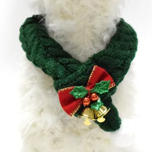 Close-up of green knitted Christmas pet scarf with red bow and gold bells