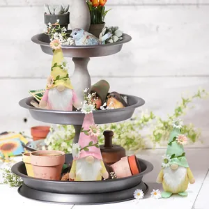 Spring flower gnomes displayed on a three-tier rustic metal garden tray stand