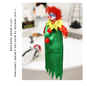 Detail of a scary Halloween clown hanging doll with red hair and green satin dress.