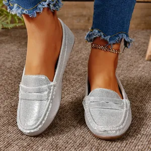 Close-up of women's shiny silver flat loafers with soft non-slip soles and casual style