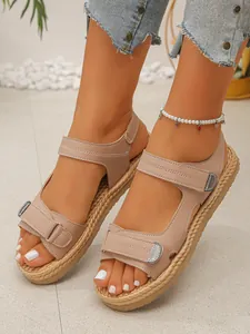 Primo piano di eleganti sandali beige da donna con zeppa e cinturini in velcro regolabili