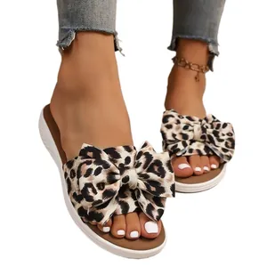 Chic women's leopard print flat sandals featuring a large bow knot for summer beach comfort