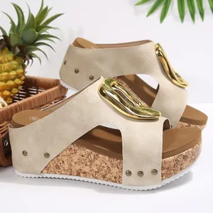 Close-up of women's beige wedge sandals with gold buckle and cork textured platform