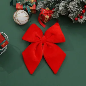 Detailed view of a large red velvet Christmas bow ornament with festive gift decorations
