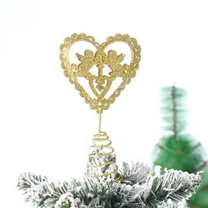 Detailed view of a gold glittery heart-shaped tree topper with angels on snowy branch