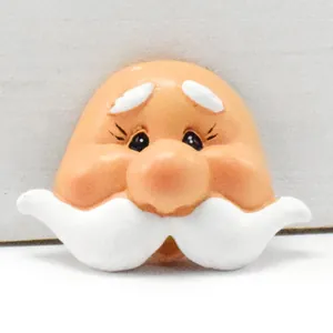 Detail of a painted resin gnome face with white mustache for DIY doll making.