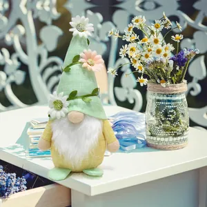 Spring floral gnome plush doll decorated with daisies and green hat on a white table