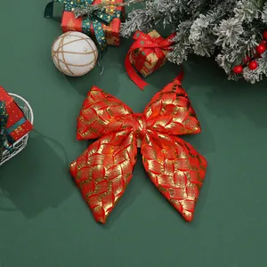 Detailed view of a red and gold metallic Christmas bow on festive green background