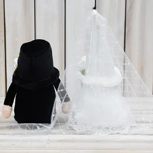 Back view of plush wedding gnomes with black tuxedo and elegant lace veil details.