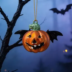 Dettaglio decorazione zucca di Halloween con ali di pipistrello appesa a un ramo
