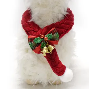 Close-up of red knitted Christmas pet scarf featuring a plaid bow and festive gold bells