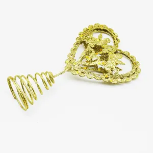 Golden glitter heart Christmas tree topper with angel detail shown on white background