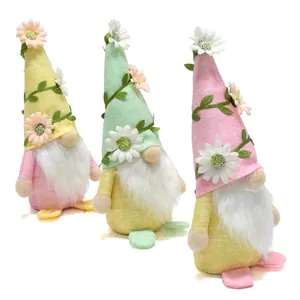 Three handmade spring gnomes decorated with daisy flowers and vines in pastel colors