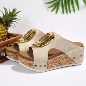 Side view of elegant beige wedge sandals with large gold buckle and cork platform sole