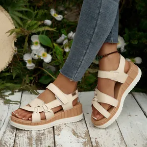 Close-up of beige platform wedge sandals featuring a stylish wooden textured sole.