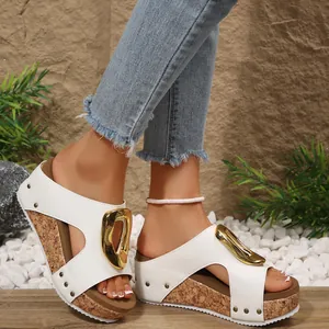 Detailed view of white platform wedge sandals with gold buckle and rivet accents for women