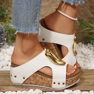 Detailed view of white platform wedge sandals with a decorative gold buckle.