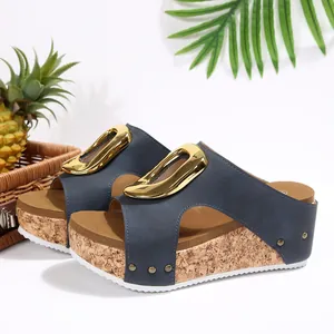 Close-up detail of blue wedge sandals with a textured cork platform and a large gold buckle