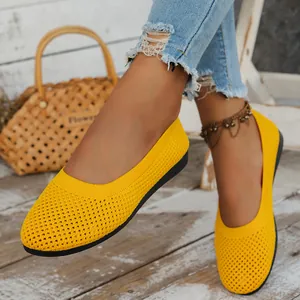Close-up of bright yellow knit mesh ballet flats on model with rustic background