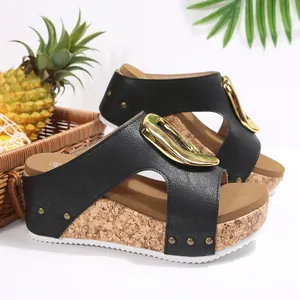 Side view detail of black wedge sandals featuring a stylish gold buckle and cork sole