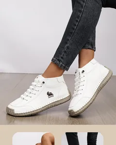 Close-up detail of white hand-stitched casual ankle boots with flat anti-slip rubber sole