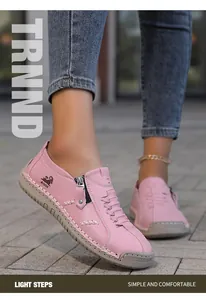 Detalle de mocasines rosa hechos a mano con cremallera y costuras cruzadas