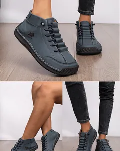 Detailed view of blue hand-stitched casual ankle boots with leather texture on model