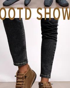 Close-up view of hand-stitched brown leather casual boots with dark denim jeans