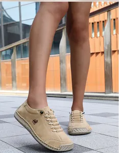 On-foot view of beige hand-stitched slip-on loafers for men in outdoor setting