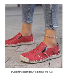 Vista detallada de zapatos de cuero rojo con costuras blancas y vaqueros azules