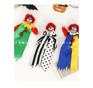 Close-up of three different Halloween horror clown doll decorations on a white background.