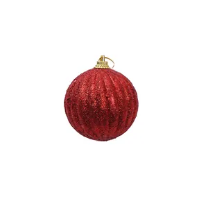 Gros plan d'une boule de Noël rouge scintillante avec des rainures pour la décoration.