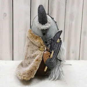 Detail of Viking warrior gnome plush with fur cape and axe against wooden background