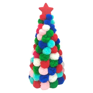 Detailed view of a colorful pom-pom Christmas tree tabletop ornament with a red star