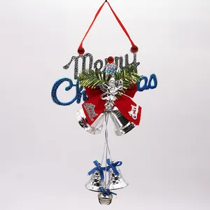 Close-up of silver Christmas bells with Merry Christmas sign and red angel bow.