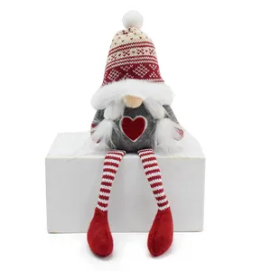 Detailed shot of a Nordic knitted Christmas gnome with heart pattern and long dangling legs
