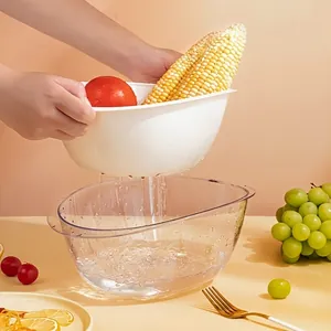 Detailed view showing water draining from the white inner basket into the transparent outer bowl