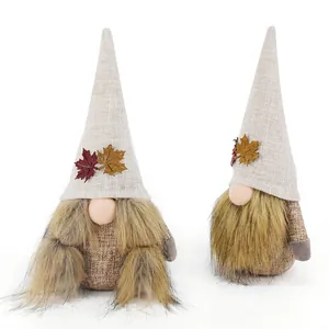 Detailansicht von zwei handgefertigten Herbstgnomen mit Ahornblatt-Dekor für das Erntefest