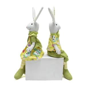 Detaillierte Ansicht von handgemachten Osterhasen-Figuren in gelben und grünen Outfits.