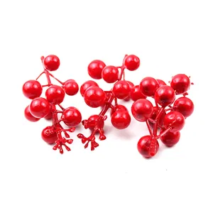Vue détaillée de baies rouges artificielles de Noël montrant une couleur vive et lisse.