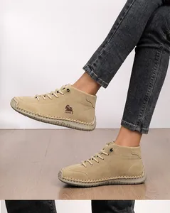 Side view of beige hand-stitched casual ankle boots featuring a textured nubuck finish