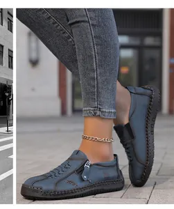 Detalle de mocasines de cuero azul cosidos a mano con un diseño de cremallera lateral único