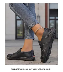 Detalle de cerca de mocasines de cuero negro cosidos a mano con pantalones vaqueros