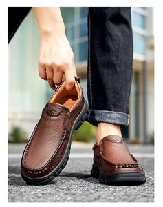 Detailed view of men's brown textured leather outdoor casual shoes on pavement