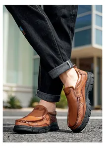 Detail view of men's outdoor casual brown leather shoes worn with black jeans on street.