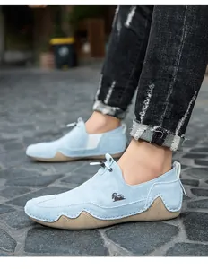 Dettaglio di scarpe casual slip-on celesti traspiranti su un percorso di pietra.